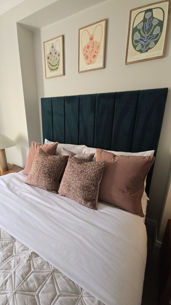 Teal upholstered headboard and pink cushions in the refurbished Paddington bedroom