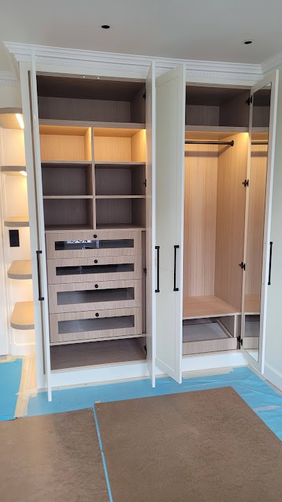 Custom wardrobe interior with illuminated shelves, fitted drawers and hanging space in Versailles