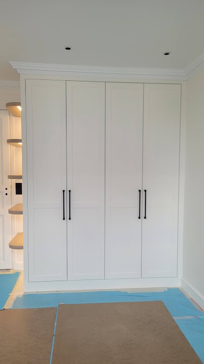 White panelled fitted wardrobe with dark handles, made in our Polish workshop for a Versailles home